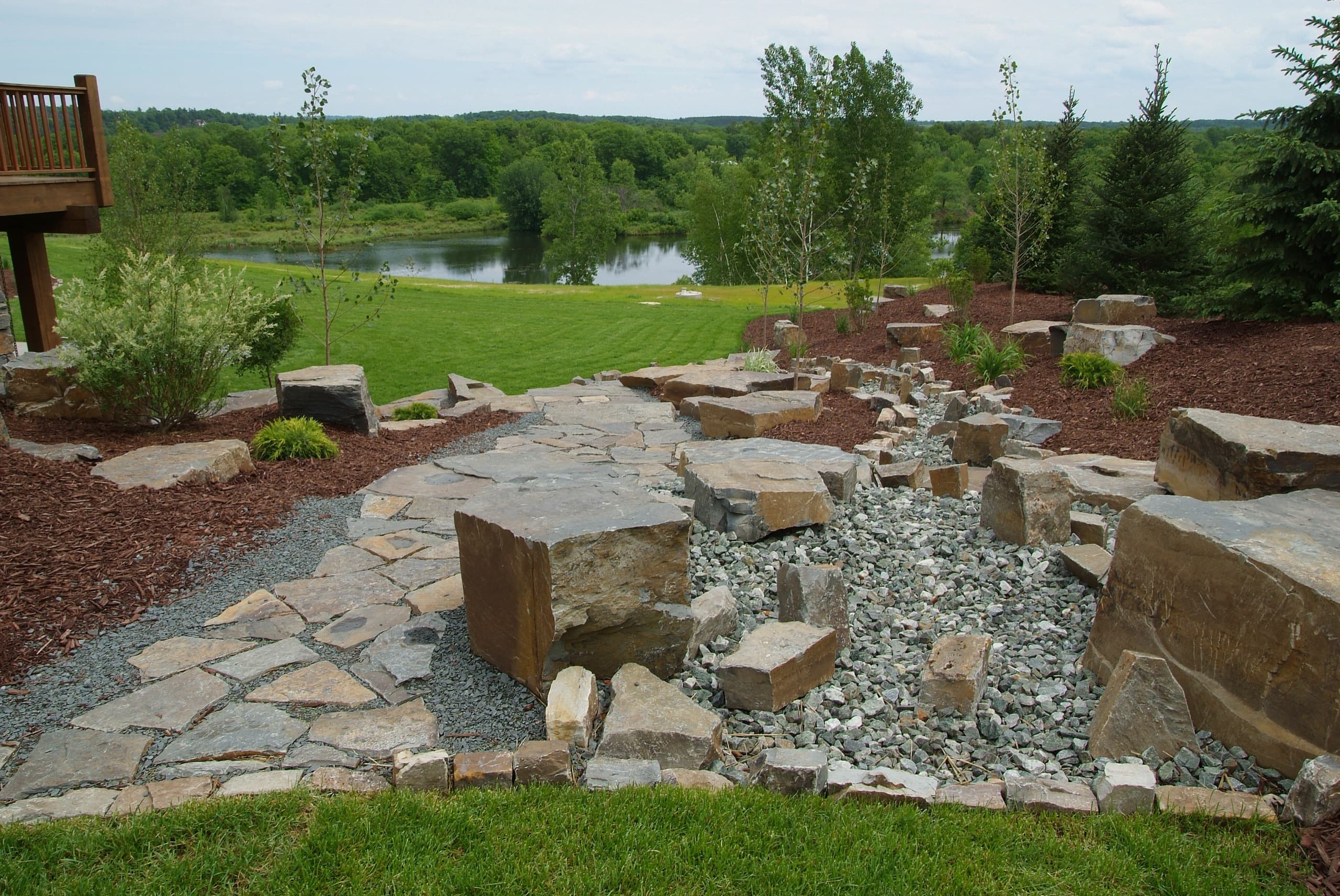 Lakeside boulder and dry creek water feature with flagstone path