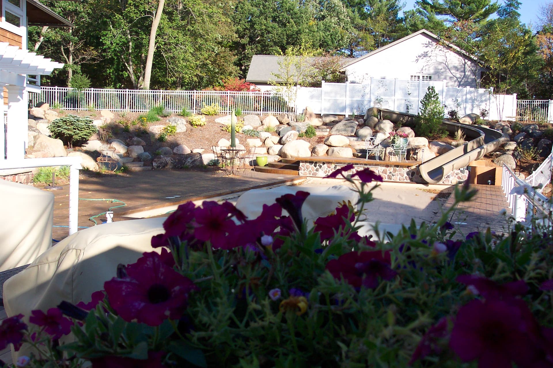 Lakeside boulder patio and entertaining area with flower beds