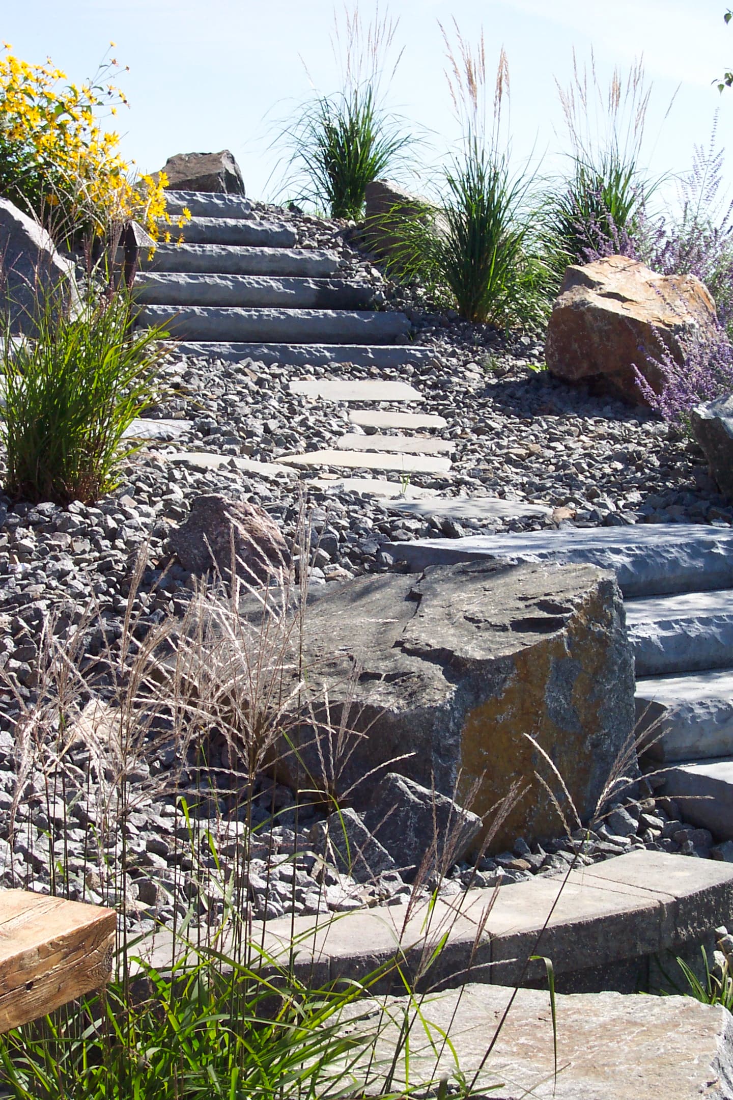 Curved natural stone steps winding through boulder garden