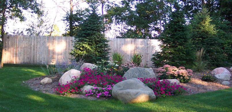 Colorful annual flower garden accented with natural boulders