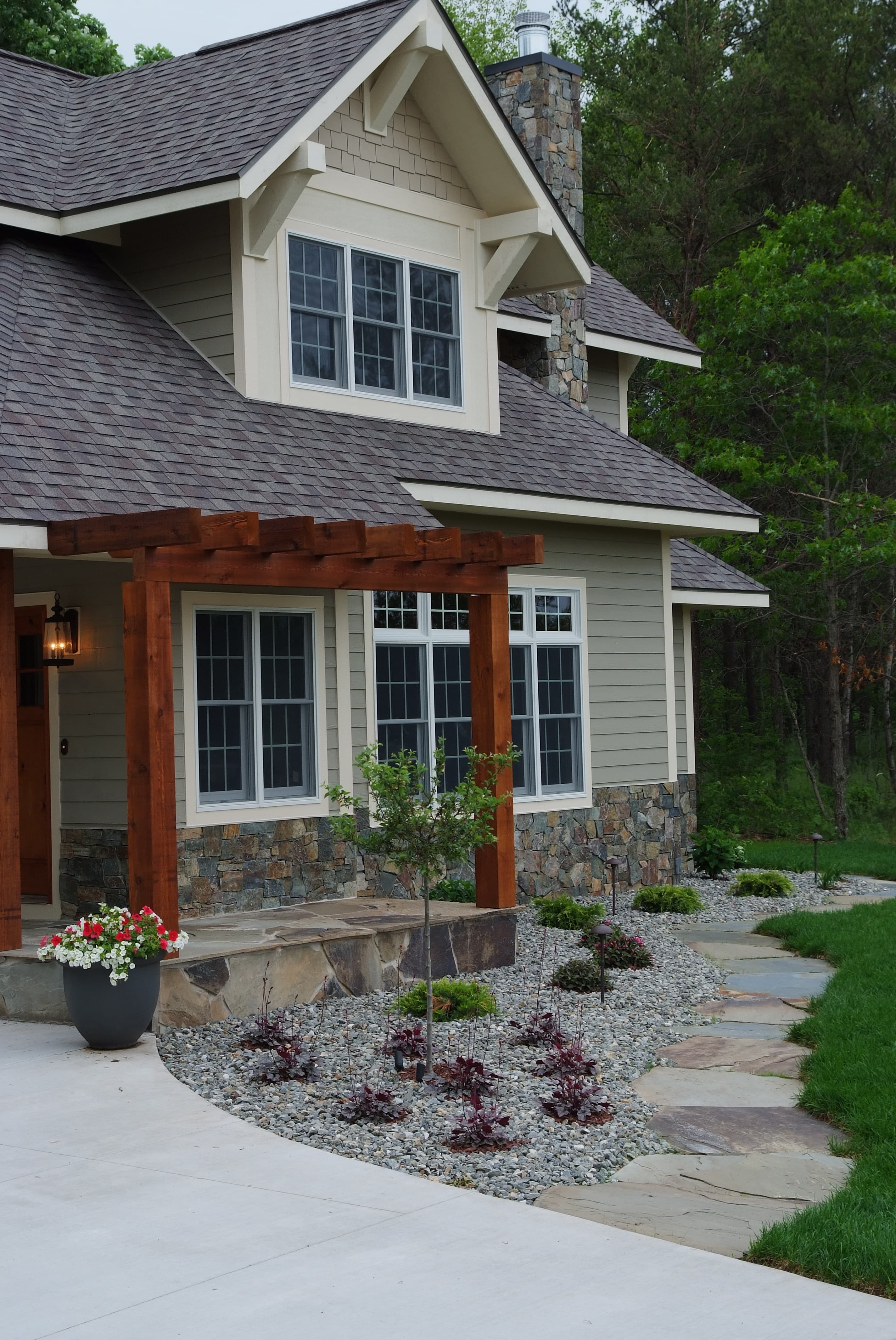 Custom home entry with stone walkway and pergola