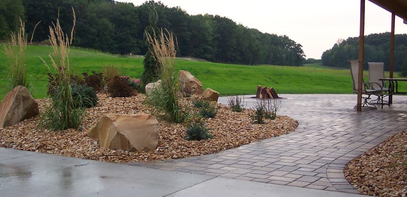 Paver patio with adjacent rock garden and fire pit area