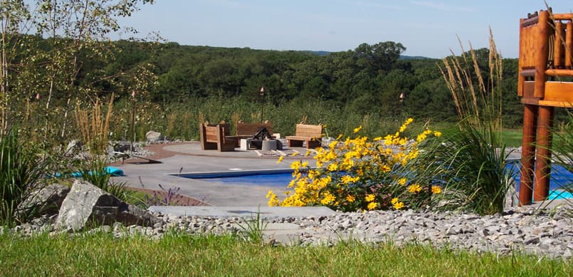 Pool area with surrounding landscape design and ornamental plantings