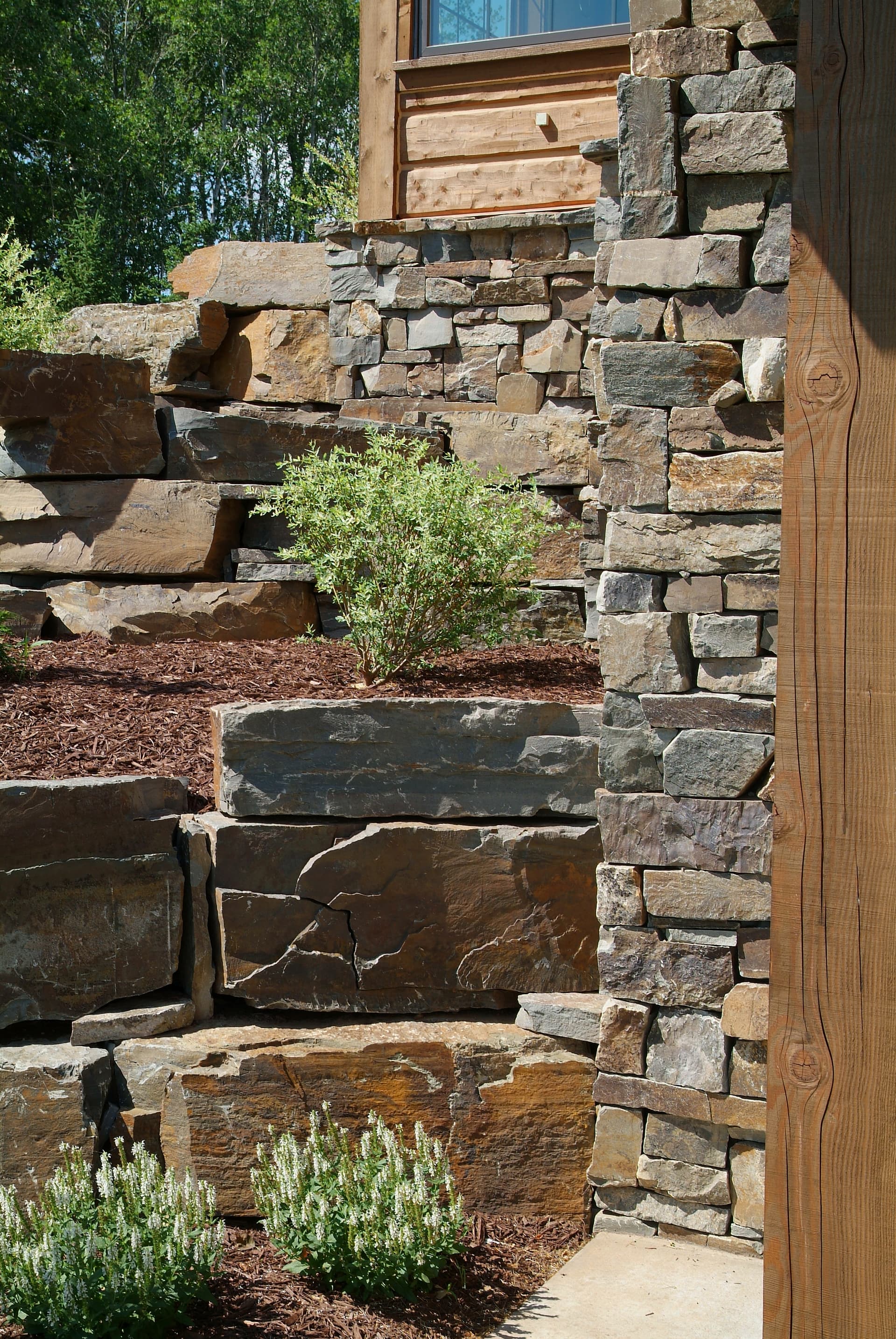 Stacked stone retaining wall with tiered planting beds