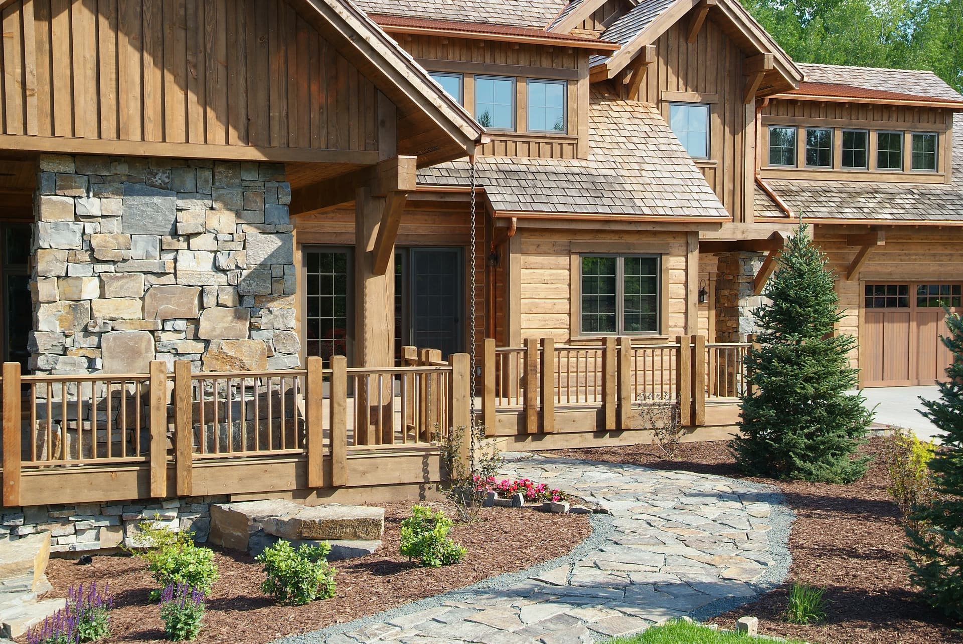Timber and stone home entry with flagstone walkway and mulch beds