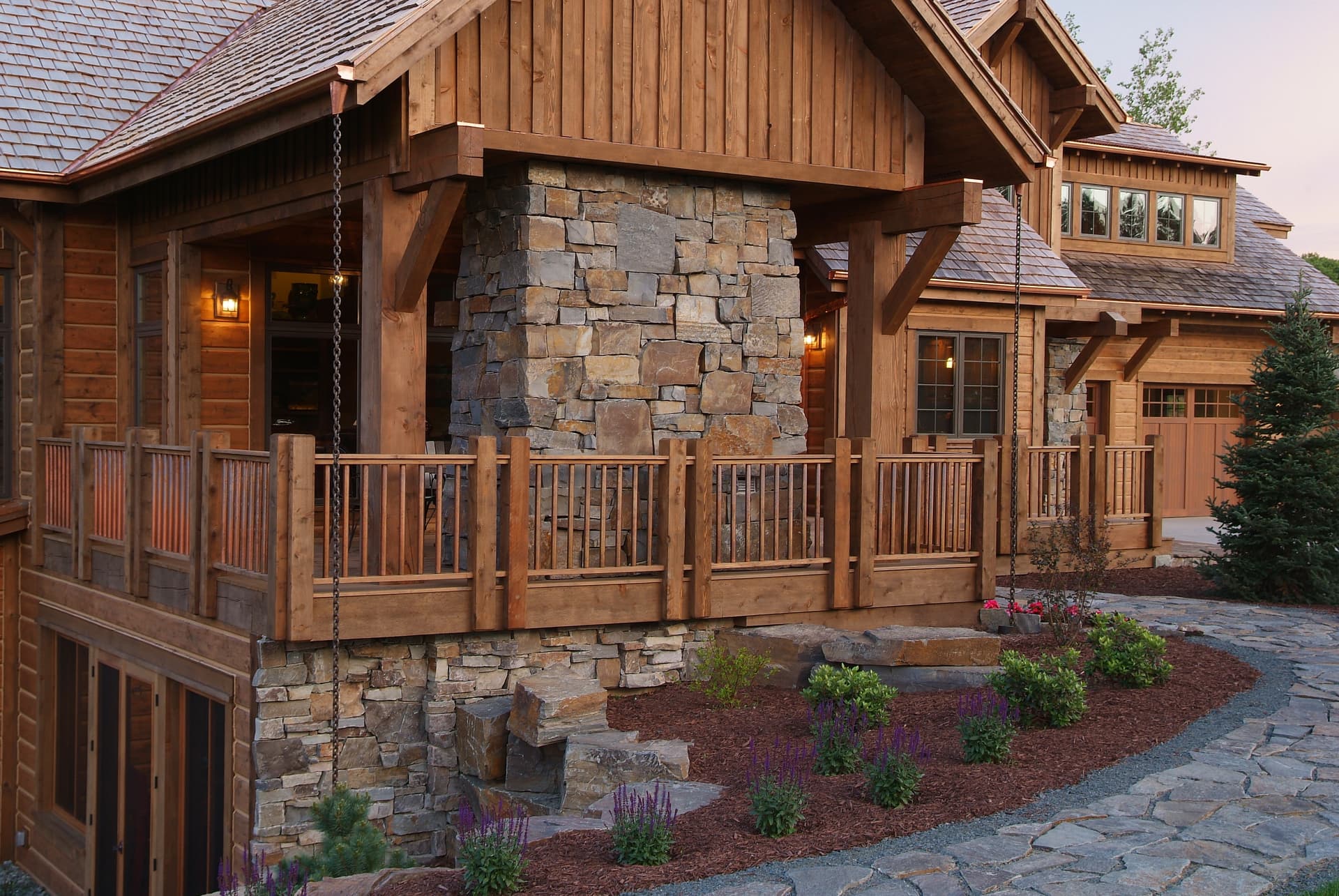 Timber home stone porch with perennial beds and cobbled walkway